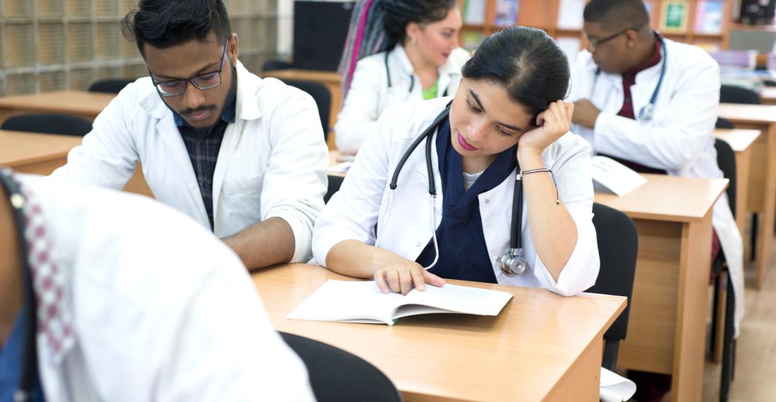 Doctors sitting at desks studying and reading.